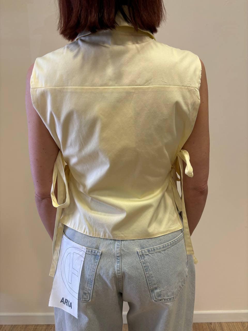 Camicia smanicata gialla con top e dettaglio laccetti