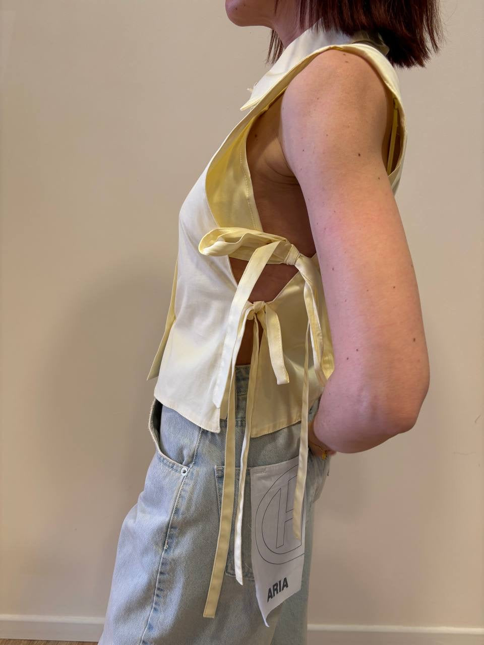 Camicia smanicata gialla con top e dettaglio laccetti