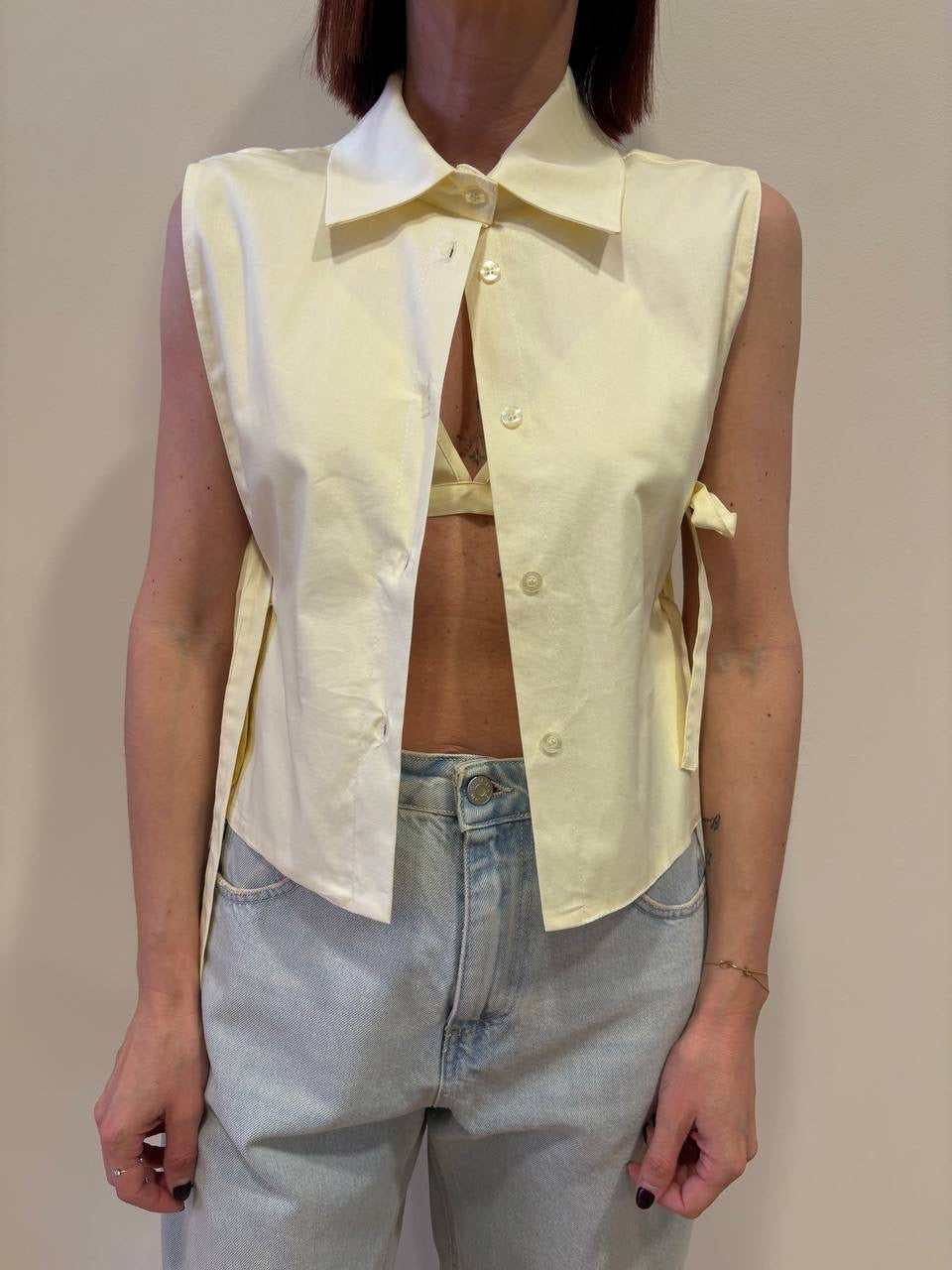 Camicia smanicata gialla con top e dettaglio laccetti